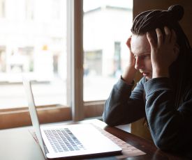 Un homme a l'air abattu regarde l'écran de son PC portable