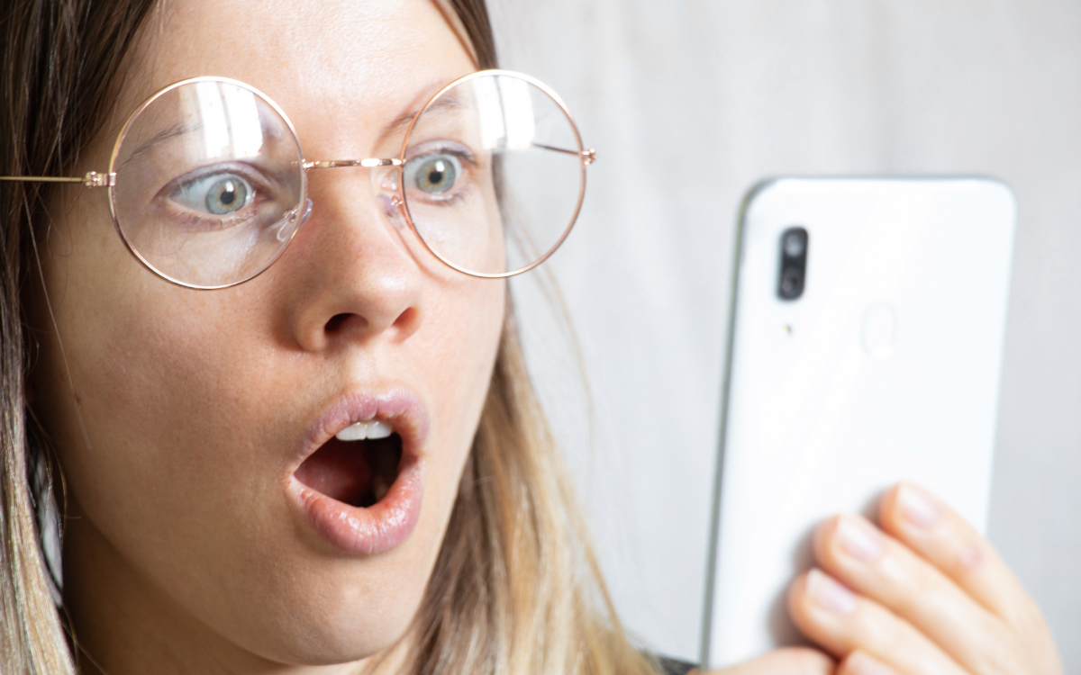 Femme choquée devant smartphone
